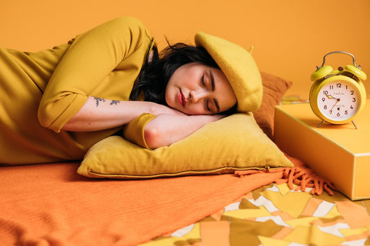 Woman sleeping in a yellow themed room. Blog. The crucial role of sleep.