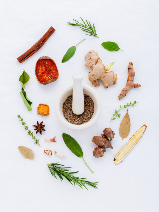 Colorful herbs and spices laid out on white table. Blog. Best hers and spices to boost your immune system.